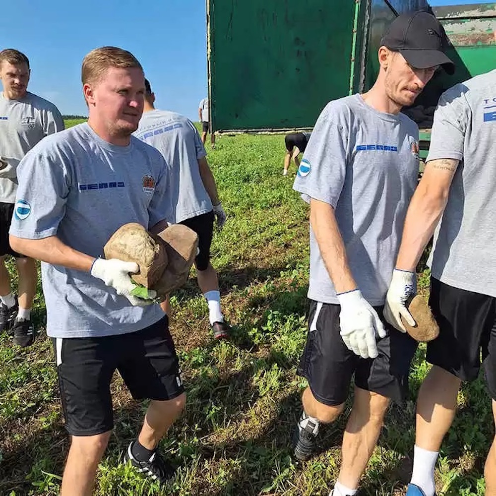 Футболисты «Торпедо-БЕЛАЗ» в разгар летней страды собирают камни вместе с членами тренерско-административного штаба клуба. 15 августа 2023 года. Фото: mlyn.by.