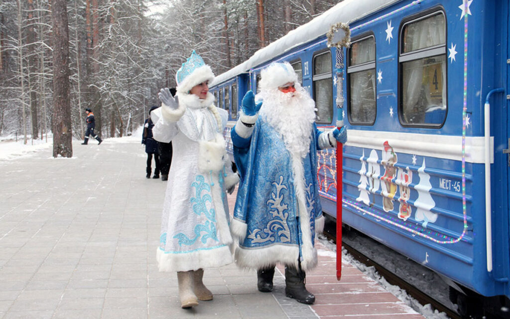Дед Мороз и Снегурочка на фоне поезда БЖД.